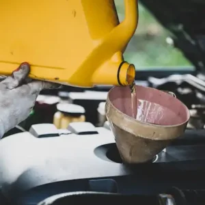cierre mecanico de automoviles vertiendo mano y reemplazando aceite fresco en el motor